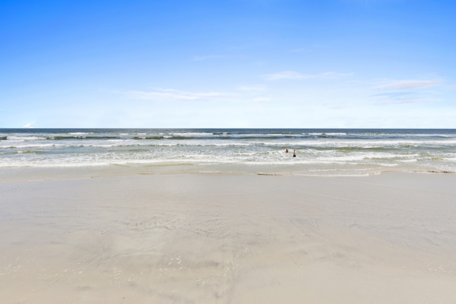 Wide sandy beach and rolling Atlantic surf under a clear sky