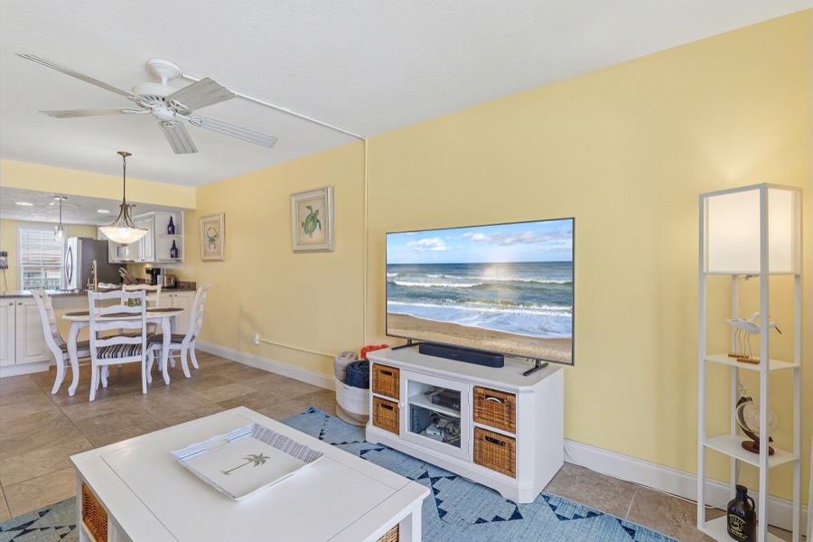 View across the living room toward the TV, dining table, and kitchen