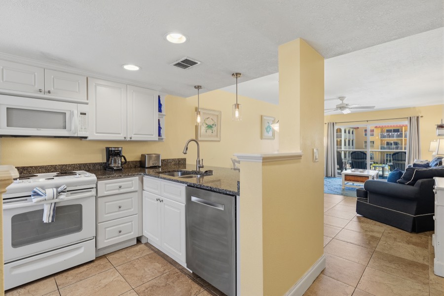 Kitchen with white cabinets, granite counters, and dishwasher