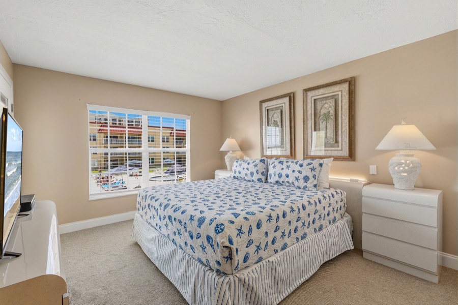 Bedroom with blue seashell-print bedding and white nightstands