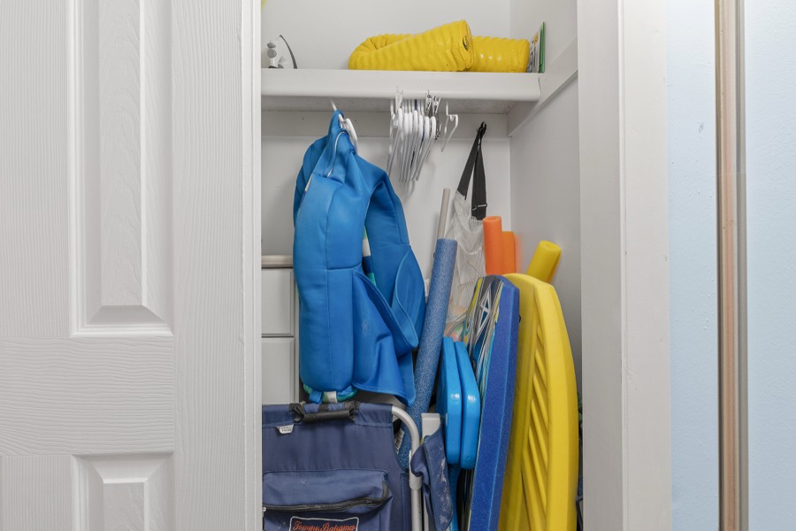 Closet stocked with beach chairs, boogie boards, pool noodles, and a beach cart