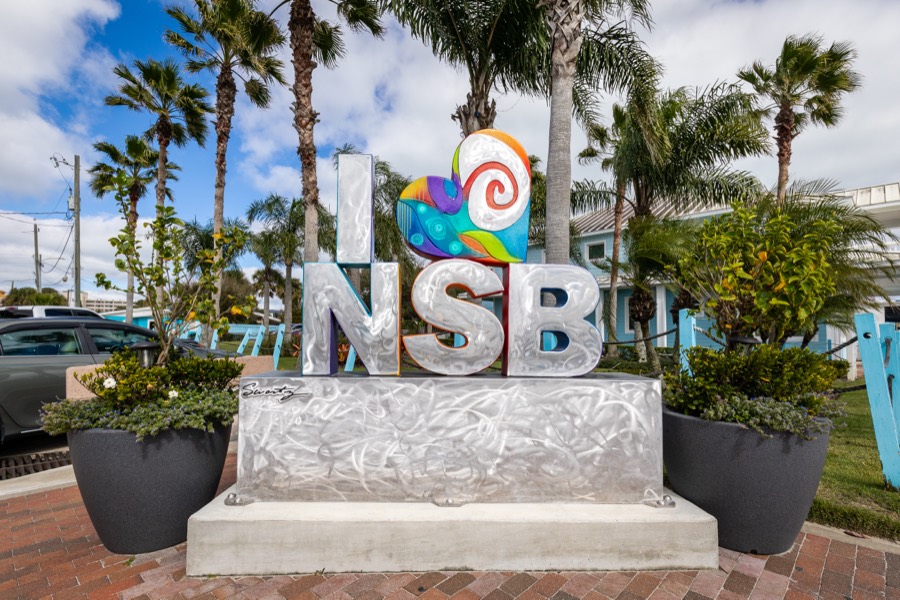 Colorful I-heart-NSB sculpture sign surrounded by palm trees