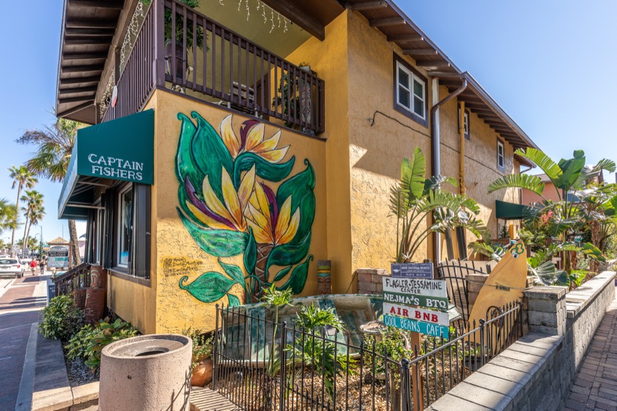 Street corner with a tropical flower mural and landscaped signage