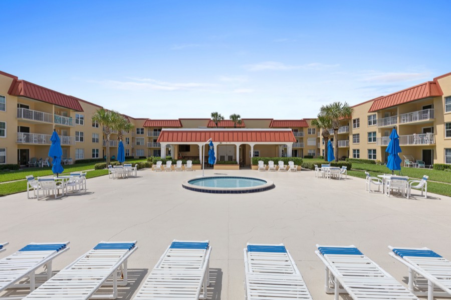 Round courtyard pool with cabana and umbrellas